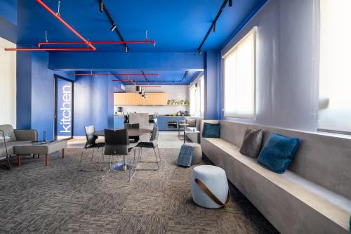 a living room with blue ceilings and a long couch at Swan Generation Porto Alegre in Porto Alegre