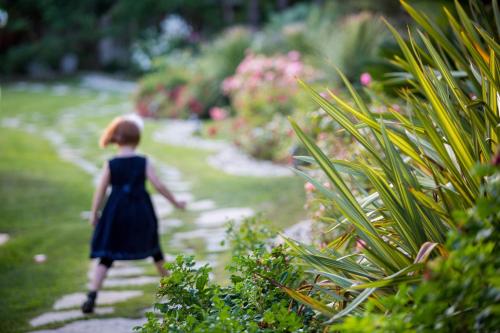 a young girl walking down a path in a garden at Hotel Ares in Pontinia