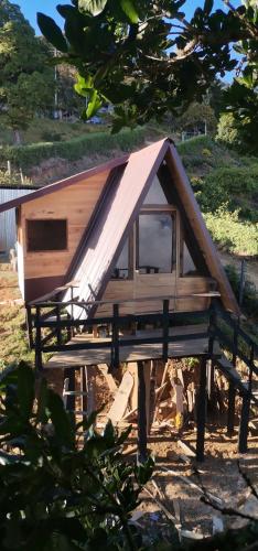 a small wooden cabin with a pitched roof at Glamping Jaulares Mountain in Rivas