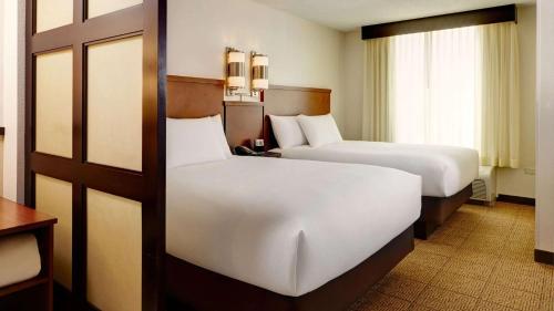 a hotel room with two beds and a window at Sonesta Select Atlanta Duluth in Duluth
