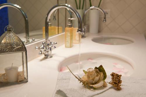 a bathroom sink with a flower on a towel at Afrodite in Amalfi