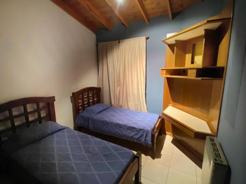 a small room with two beds and a window at Amanecer de Oro in Guaymallen