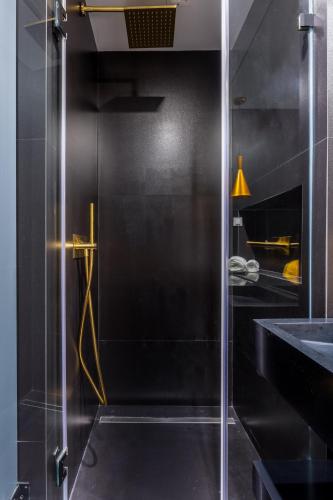 a glass shower door in a bathroom with a sink at Bairro Alto Music Guest House in Lisbon