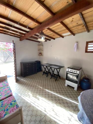 a living room with a table and a stove at Chalé do Coqueiro in Luis Correia