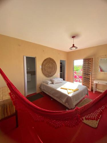 a bedroom with a bed and a hammock at Chalé do Coqueiro in Luis Correia