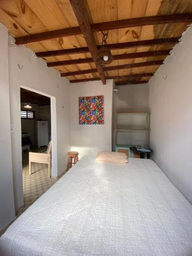 a bedroom with a large bed with a wooden ceiling at Chalé do Coqueiro in Luis Correia