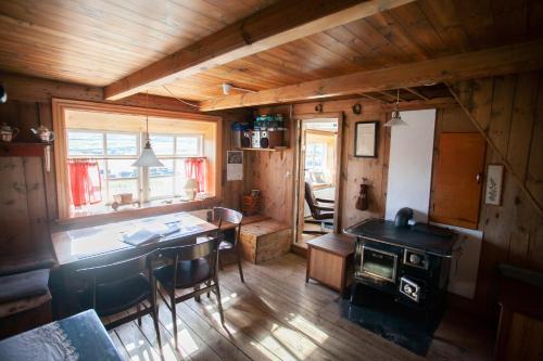 Una habitación con una mesa y una estufa en una cabaña en The Real Faroese Experience, en Skálavík