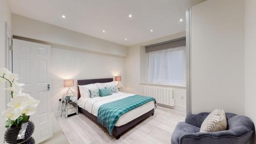 1 dormitorio con 1 cama y 2 sillas en Chic Apartment by Hyde Park, en Londres