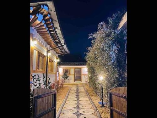 a house with a fence and a walkway at night at Adam Guesthouse in Gyeongju