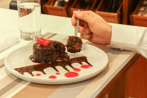 a person eating a piece of chocolate cake on a plate at Hotel Unu in Huancayo
