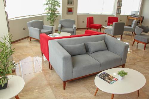 a living room with a couch and tables and chairs at Hotel Unu in Huancayo