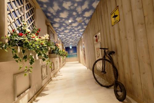 a bike is parked in a hallway with flowers at HOTEL555 秦野 in Hadano