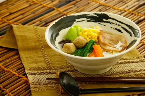 a bowl of soup with vegetables in it on a table at HOTEL555 秦野 in Hadano