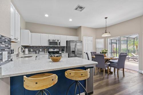 a kitchen and dining room with a table and chairs at WindsorHills Villa Pool Resort Amenities Minutes to Disney in Orlando