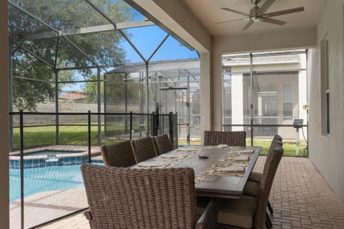 a dining room with a table and chairs and a pool at WindsorHills Villa Pool Resort Amenities Minutes to Disney in Orlando