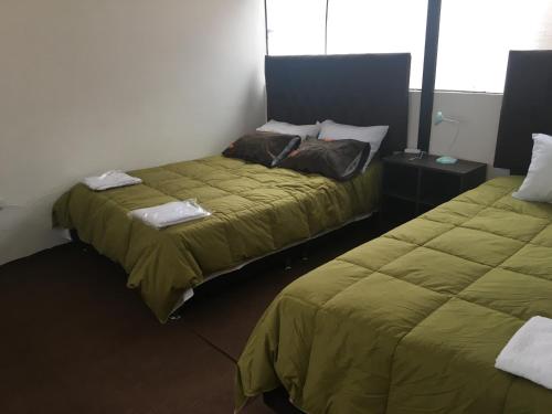 2 letti posti uno accanto all'altro in una stanza di Apartamento familiar entero Cusco x5 a Cuzco