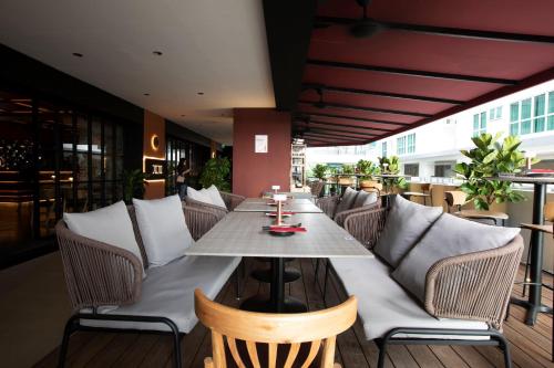 The LUMA Hotel, a Member of Design Hotels في كوتا كينابالو: مطعم على طاولة وكراسي على فناء