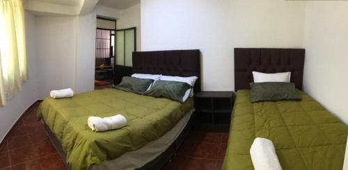 2 letti posti uno accanto all'altro in una camera da letto di Apartamento familiar entero Cusco x5 a Cuzco