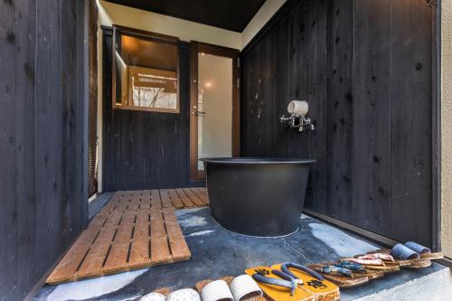 a bathroom with a tub and a wooden wall at Tofukuji Sakura & Tsuki in Kyoto