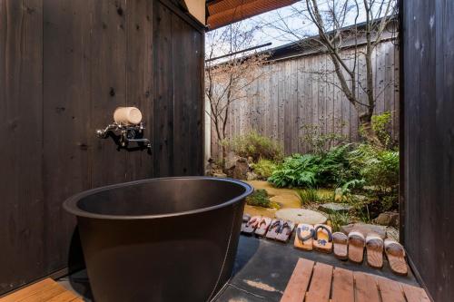 uma banheira num quintal com um jardim em Tofukuji Sakura & Tsuki em Quioto