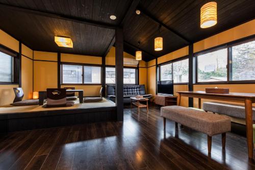 Habitación con cama, mesa y algunas ventanas. en Tofukuji Sakura & Tsuki, en Kioto