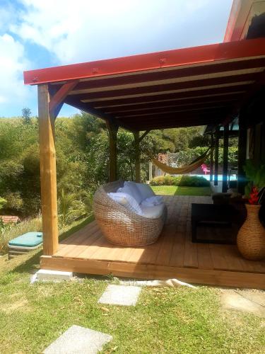 a wooden deck with a pavilion with a wicker bowl at Villa Tourmaline in Le Lorrain