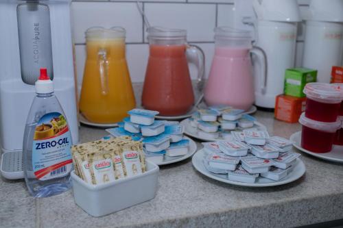 Eine Theke mit Behältern voller verschiedenfarbiger Getränke in der Unterkunft Pousada Peninsula de Buzios in Búzios