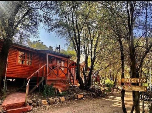 a log cabin with a sign in front of it at Rancho el Chilcal Cabañas con vista al rio in San Alfonso