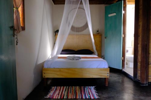 a bedroom with a bed with a canopy at Casa Kresala, Surf House in Zorritos