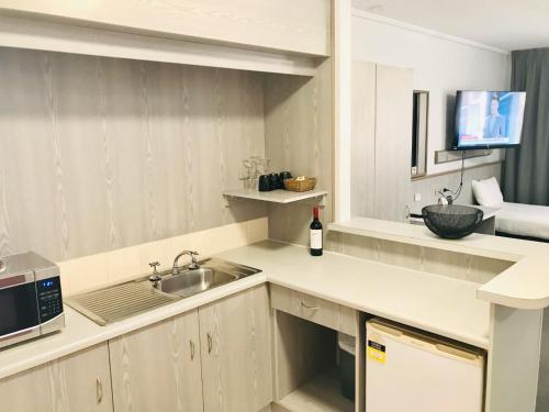 uma cozinha com um lavatório e um micro-ondas em Comfort Inn Glenelg em Adelaide