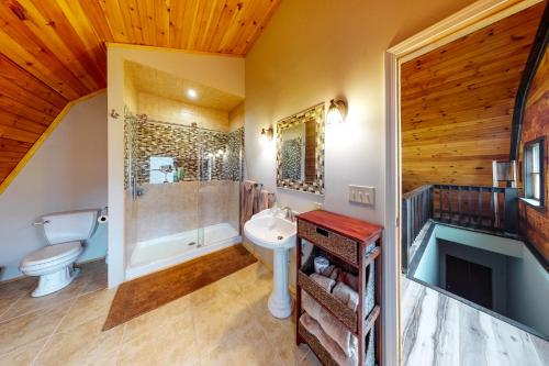 a bathroom with a toilet sink and a shower at Seneca Lake Getaway in Burdett