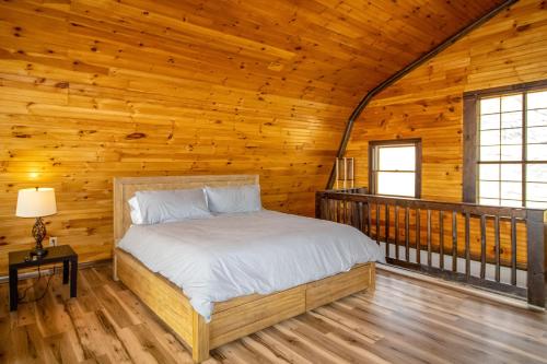 een slaapkamer met een bed in een houten hut bij Seneca Lake Getaway in Burdett