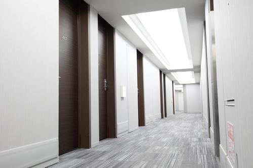 東京的住宿－銀座國際酒店，白色墙壁和木地板的办公大楼走廊