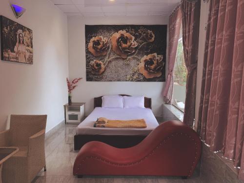 a bedroom with a bed with a red bench in it at Khách sạn SAKÊ Tiền Giang in Chợ Gạo