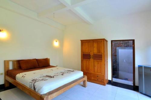 1 dormitorio con 1 cama y armario de madera en Villa Family en Canggu