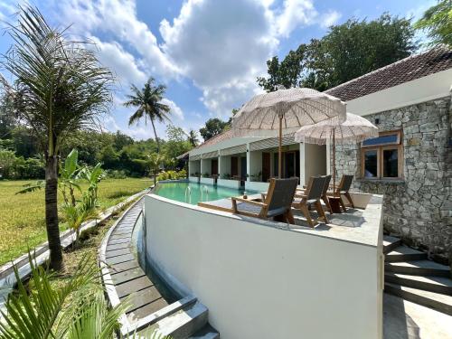 uma villa com uma piscina e uma casa em boutique villa jogja senang em Yogyakarta