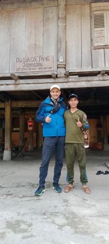two people standing in front of a building at Tày Cốc Pảng Homestay in Làng Cac