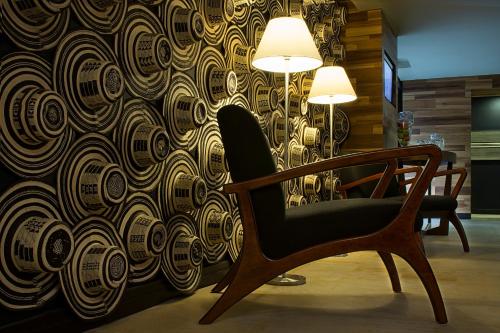 a chair in a room with a patterned wall at Movich Casa del Alferez in Cali