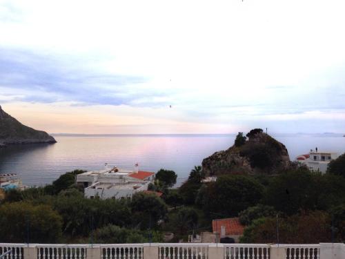 a view of the ocean with a house on a hill at Alkyonis Apartments in Panormos Kalymnos