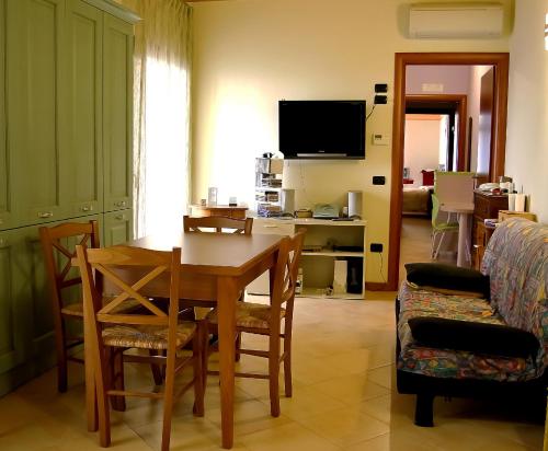 een woonkamer met een tafel en stoelen en een televisie bij B&B San Marco in Lonigo