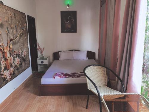 a small bedroom with a bed and a chair at Khách sạn SAKÊ Tiền Giang in Chợ Gạo