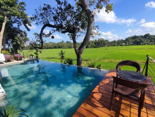 a pool with a table and chairs on a wooden deck at Villa seven faces in Galle
