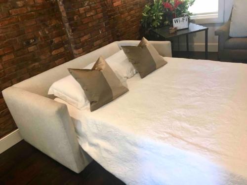 1 cama blanca grande con 2 almohadas en Luxury Design Focused, Detroit Themed Apt Near Downtown In the art District en Detroit