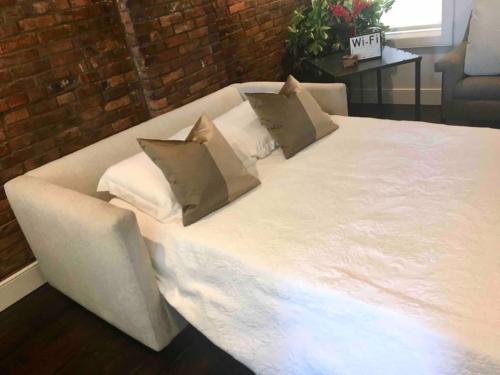 a large white bed with two pillows on it at Luxury Design Focused, Detroit Themed Apt Near Downtown In the art District in Detroit