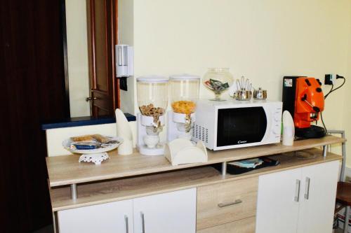 a shelf with a microwave and other items on it at Beauty House in Reggio di Calabria