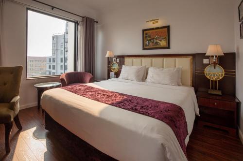 een hotelkamer met een groot bed en een raam bij Flower Garden Hotel in Hanoi