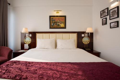 a bedroom with a large bed and two lamps at Flower Garden Hotel in Hanoi
