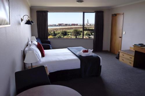 a hotel room with a bed and a large window at Baywatch Motor Lodge in Timaru