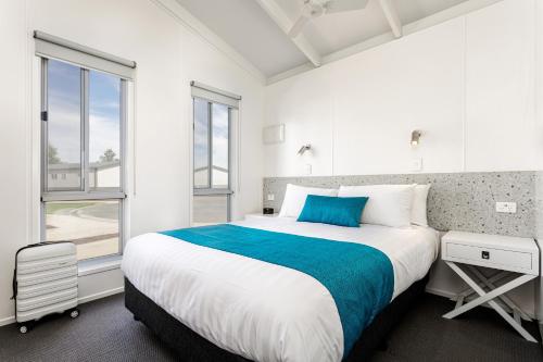 a white bedroom with a large bed and a window at RACV Cobram Resort in Cobram