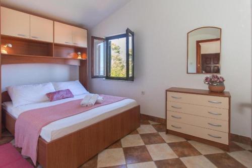 - une chambre avec un lit, une commode et un miroir dans l'établissement Apartments Sanda - 100m from sea, à Stomorska